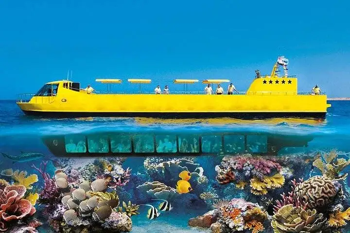 Yellow semi-submarine boat on the surface with its underwater viewing hull above a colourful coral reef and tropical fish